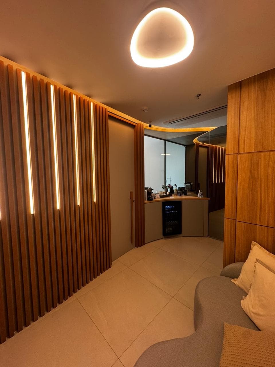 Ambiente interno da clínica com madeira e iluminação indireta